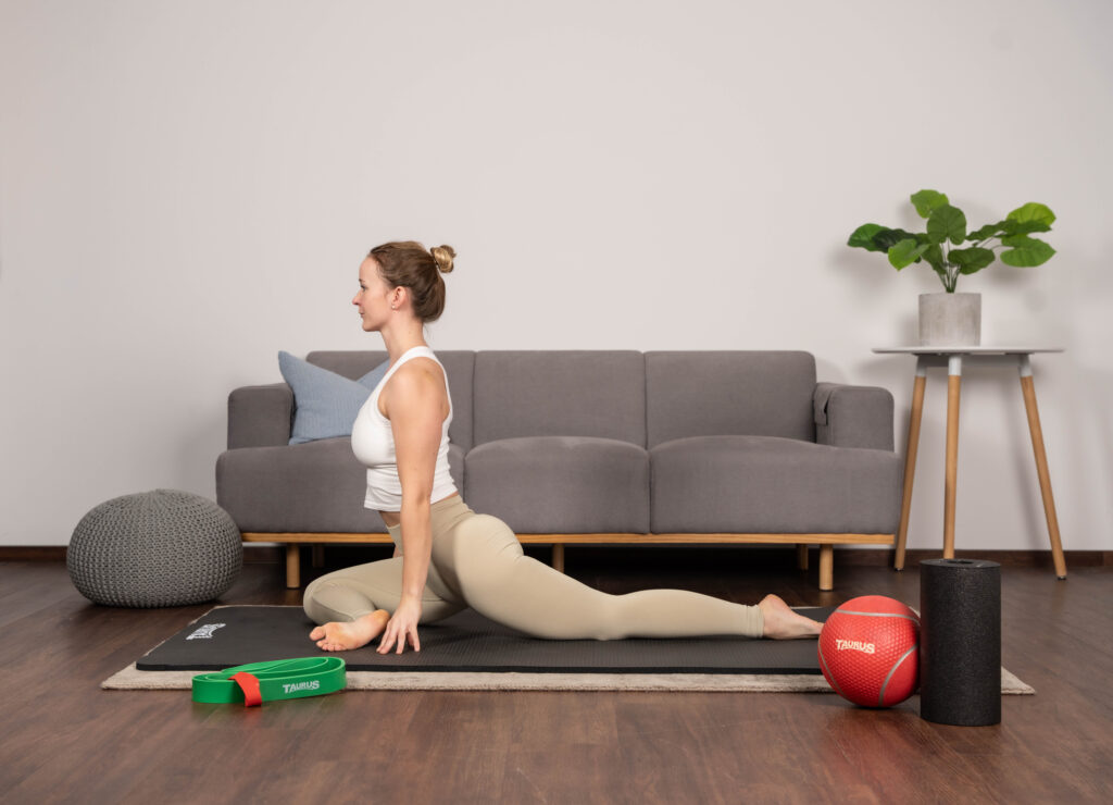 Yoga-Pose auf einer Trainingsmatte mit weiterem Functional-Equipment